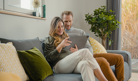 Customers on a couch with a tablet searching for a contact