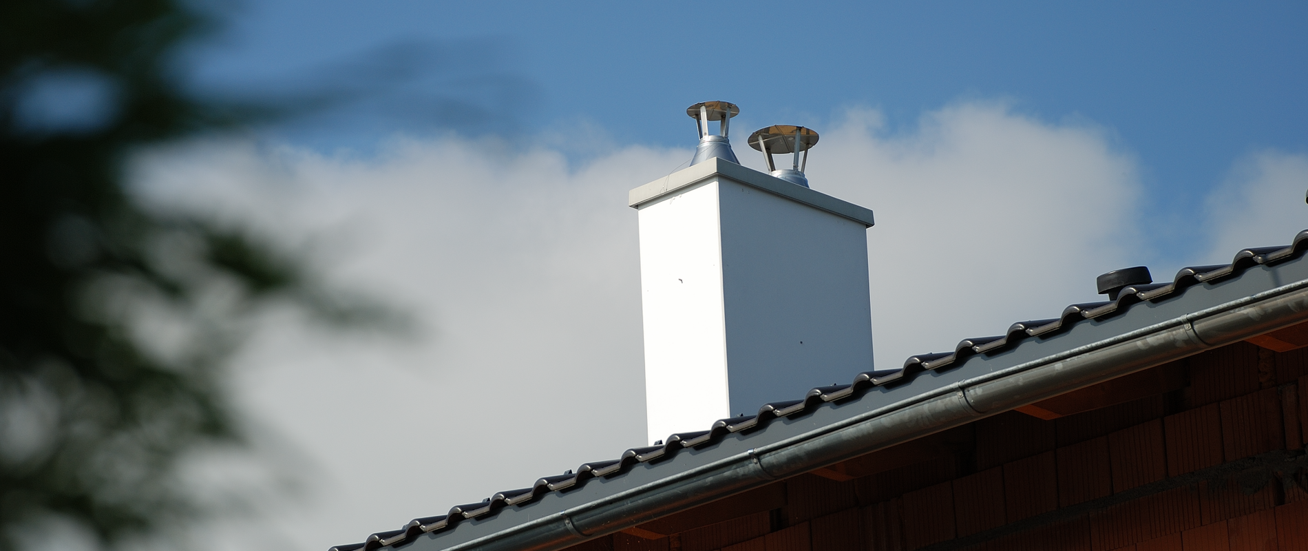 Komínový plášť nad střechou domu