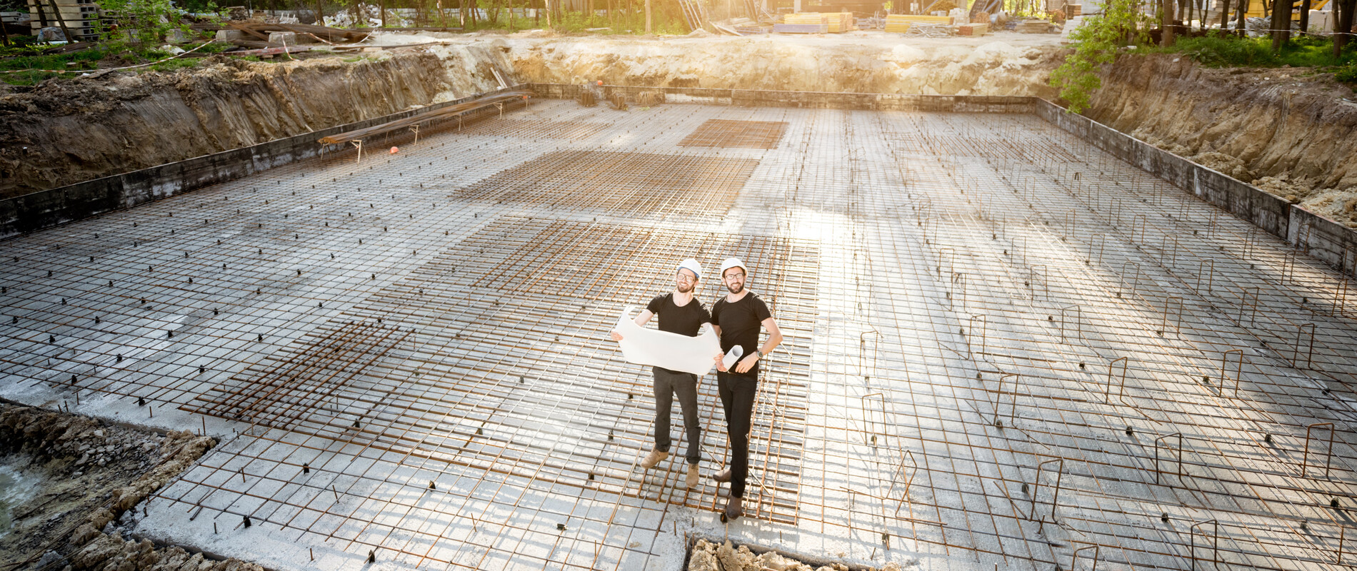Professionals on the building site on a foundation with probation poles | © AdobeStock 208121526